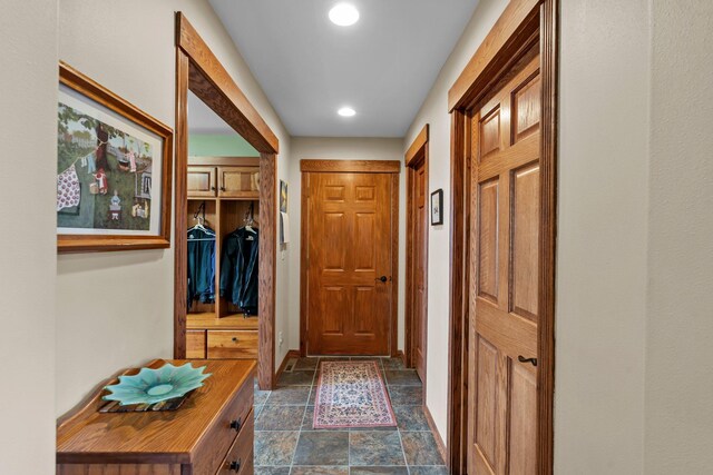 doorway to outside with baseboards, recessed lighting, and stone tile floors