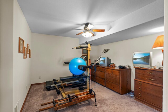 workout room with light colored carpet, a ceiling fan, baseboards, and visible vents