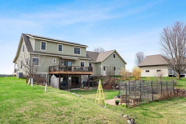 back of property with a lawn, a wooden deck, a shingled roof, and central AC
