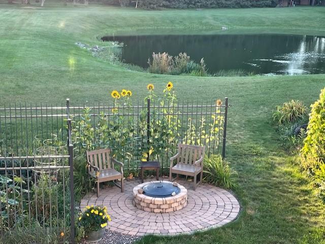 view of yard featuring a water view, a patio, and an outdoor fire pit