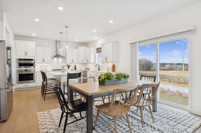 dining space featuring light wood finished floors and recessed lighting