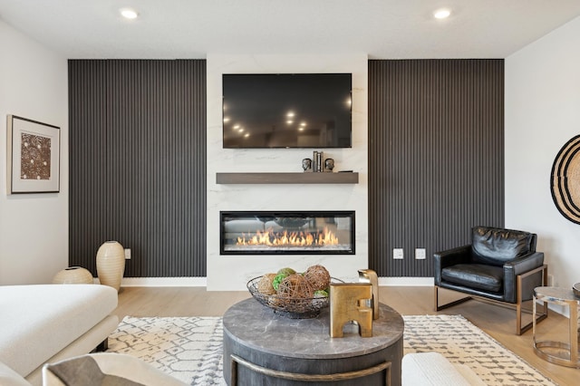 living room featuring a large fireplace, wood finished floors, and recessed lighting