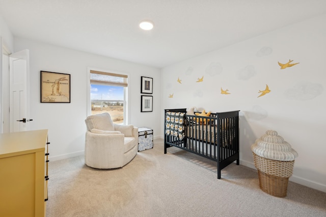 bedroom featuring light carpet, baseboards, and a nursery area