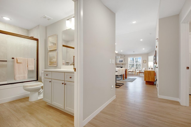 11163 184th Cir NW, Elk River, MN 55330 - full bathroom featuring shower / bath combination with glass door, visible vents, recessed lighting, wood finished floors, and vanity