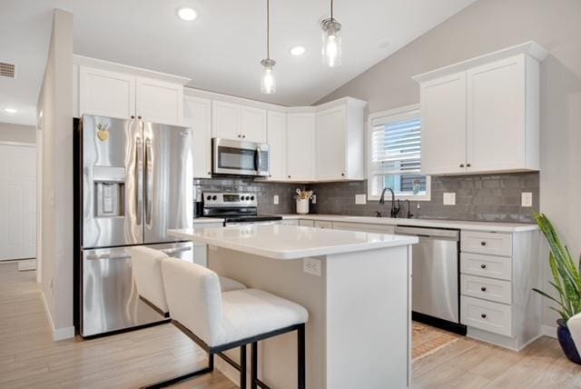 11163 184th Cir NW, Elk River, MN 55330 - kitchen featuring white cabinets, decorative backsplash, appliances with stainless steel finishes, and a kitchen island