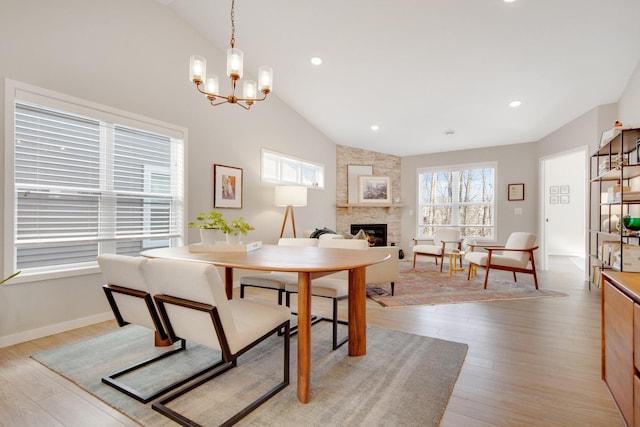 11163 184th Cir NW, Elk River, MN 55330 - dining area with vaulted ceiling, light wood finished floors, a fireplace, baseboards, and a notable chandelier