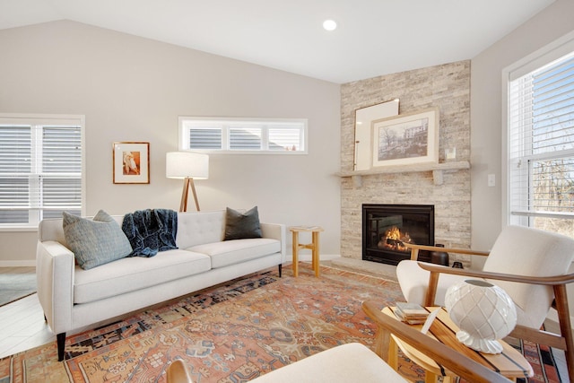 11163 184th Cir NW, Elk River, MN 55330 - living room featuring a stone fireplace, a wealth of natural light, lofted ceiling, and baseboards