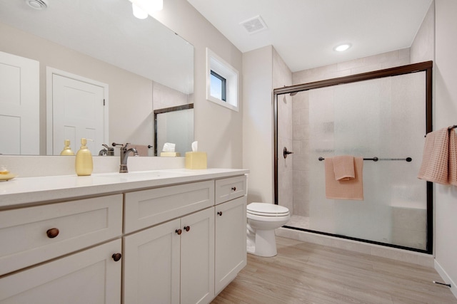 11163 184th Cir NW, Elk River, MN 55330 - bathroom featuring toilet, visible vents, wood finished floors, a shower stall, and vanity