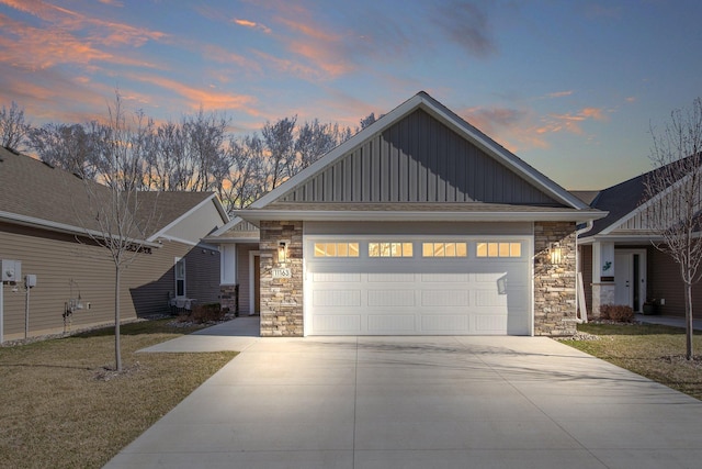 11163 184th Cir NW, Elk River, MN 55330 - view of front facade with driveway, stone siding, a garage, board and batten siding, and a yard