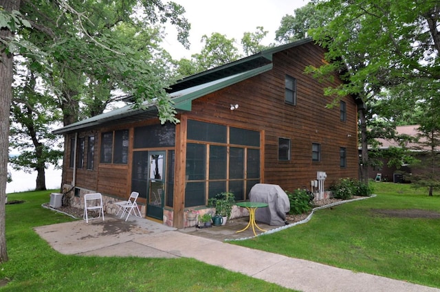 10179 Mounds Point Dr NW, Leech Lake Twp, MN 56633 - back of house with a patio, a lawn, and a sunroom