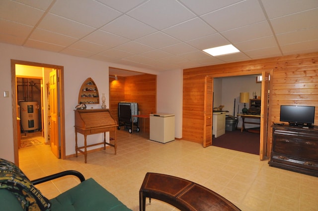 10179 Mounds Point Dr NW, Leech Lake Twp, MN 56633 - living area with wooden walls, a drop ceiling, a desk, and water heater