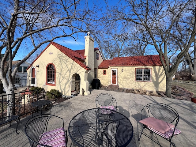 1260 Como Blvd E, Saint Paul, MN 55117 - back of property with stucco siding, a chimney, outdoor dining area, and a patio area