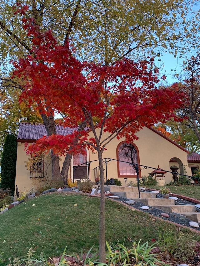 1260 Como Blvd E, Saint Paul, MN 55117 - rear view of house with stucco siding, a tile roof, and a lawn