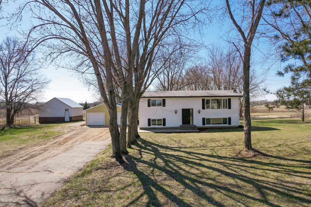 35526 Xenon St NW, Wyanett Twp, MN 55371 - bi-level home featuring a front lawn, an outdoor structure, dirt driveway, and a detached garage