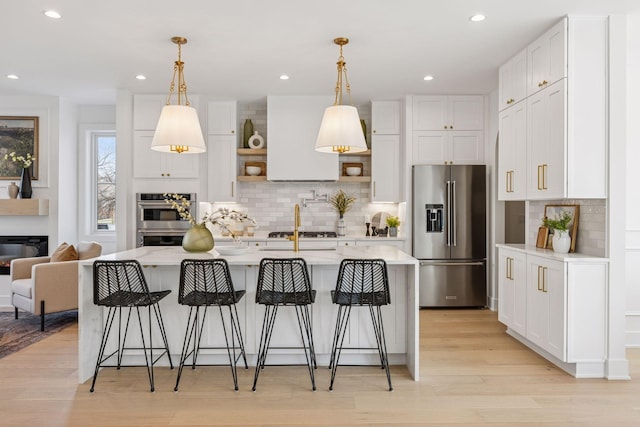 kitchen featuring appliances with stainless steel finishes, open shelves, tasteful backsplash, white cabinets, and light wood-style floors