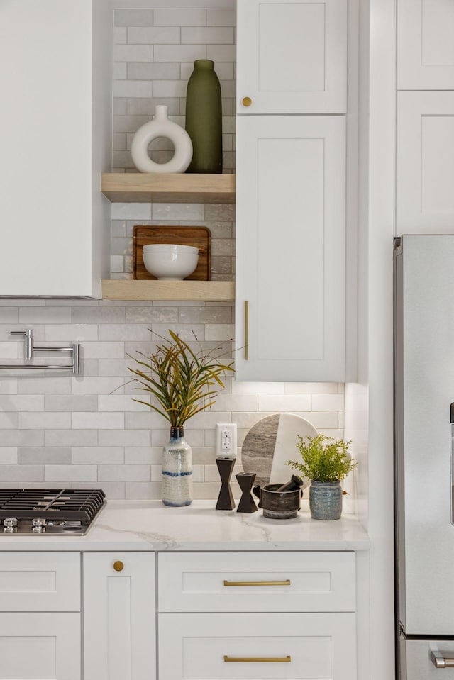 bar area featuring white fridge with ice dispenser, stainless steel gas cooktop, and decorative backsplash
