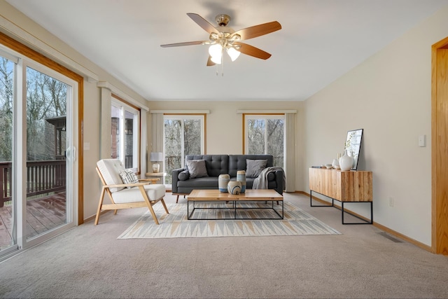 carpeted living room featuring baseboards, a ceiling fan, and visible vents