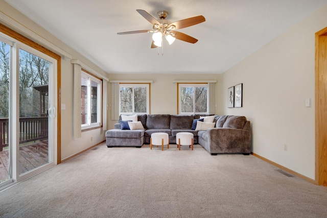 carpeted living room with visible vents, baseboards, and a ceiling fan