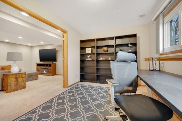 carpeted home office with baseboards, visible vents, a glass covered fireplace, and recessed lighting