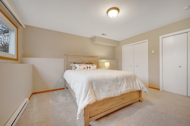 bedroom featuring a baseboard radiator, carpet flooring, visible vents, and two closets