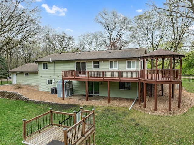 rear view of house featuring a yard, an outbuilding, a shed, a gazebo, and a wooden deck
