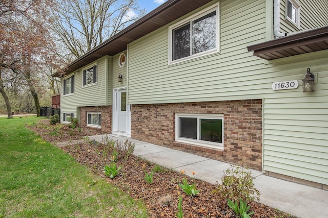 view of property exterior featuring a yard and brick siding