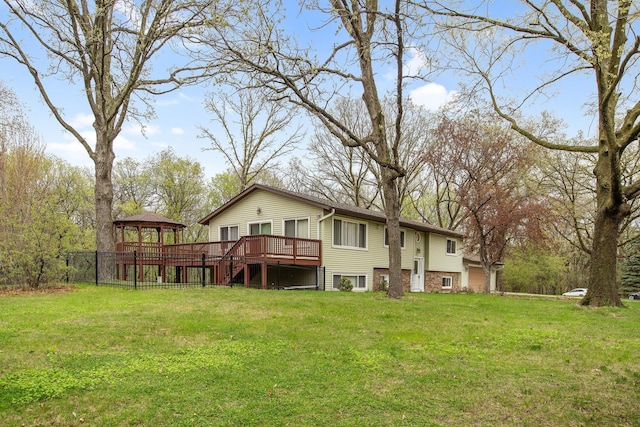 back of property featuring a lawn, a gazebo, and a deck