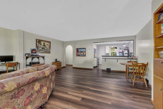 2021 6th St SW, Willmar, MN 56201 - living area featuring dark wood-style floors, arched walkways, and baseboards