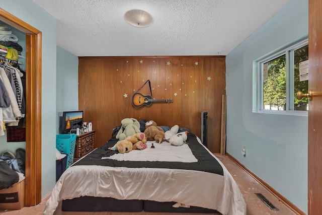 2021 6th St SW, Willmar, MN 56201 - bedroom with a textured ceiling, wood walls, and a closet
