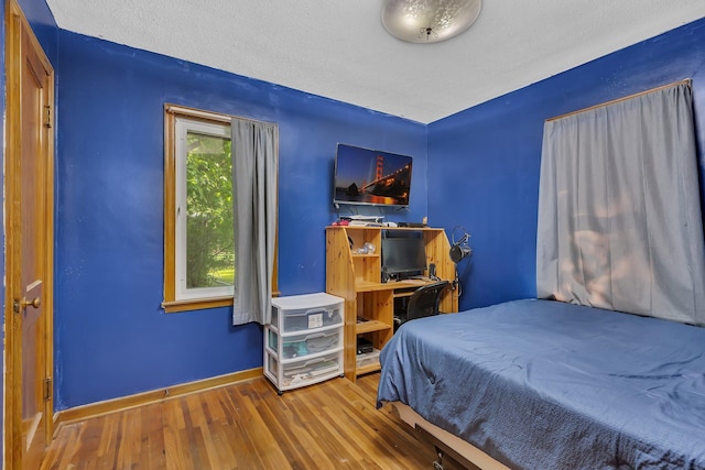 2021 6th St SW, Willmar, MN 56201 - bedroom with wood finished floors, baseboards, and a textured ceiling