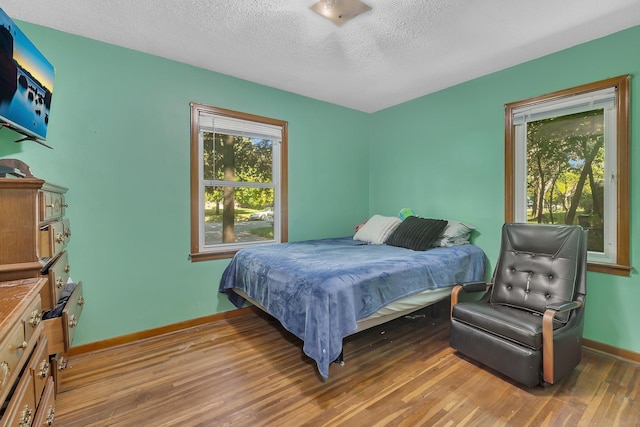 2021 6th St SW, Willmar, MN 56201 - bedroom featuring wood finished floors, a textured ceiling, and baseboards