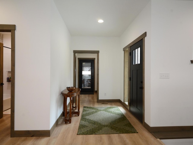 hallway featuring wood finished floors, recessed lighting, and baseboards