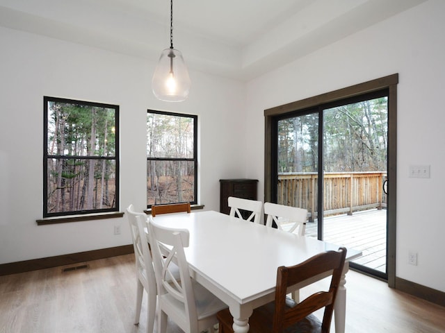 dining room featuring wood finished floors, visible vents, and plenty of natural light
