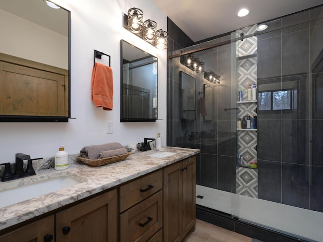 bathroom with recessed lighting, walk in shower, double vanity, and a sink