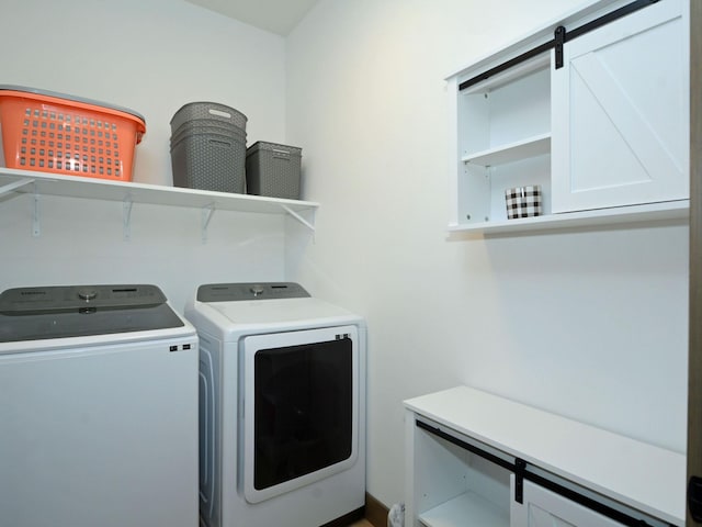 clothes washing area with washer and dryer and cabinet space