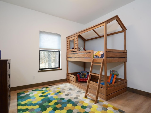 bedroom featuring baseboards, visible vents, and wood finished floors