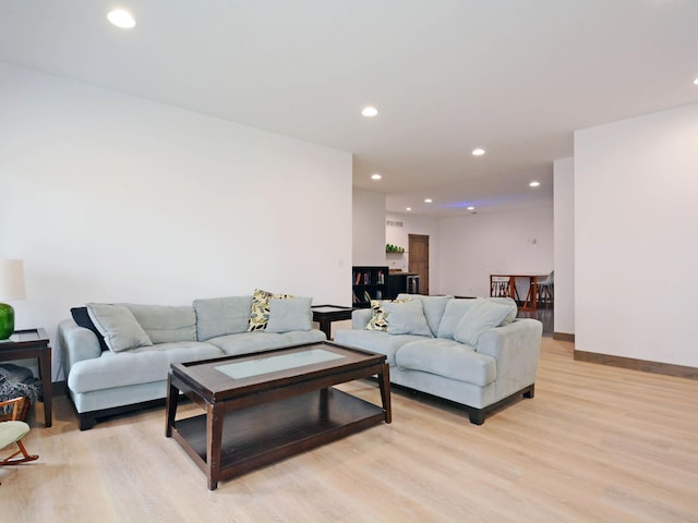 living room featuring recessed lighting, light wood finished floors, and baseboards