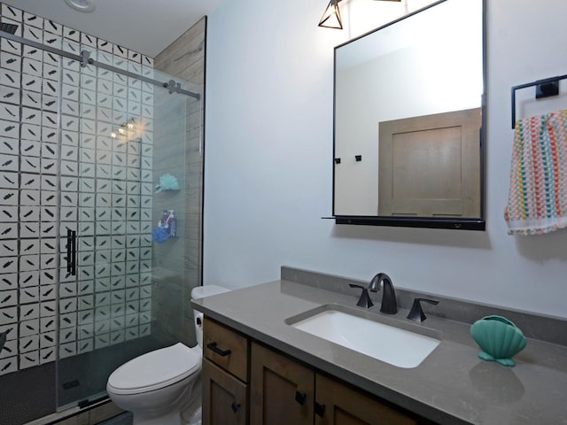 full bath featuring toilet, vanity, and a stall shower