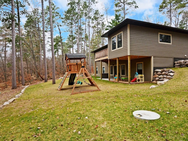 rear view of property with a lawn, a patio, and a playground