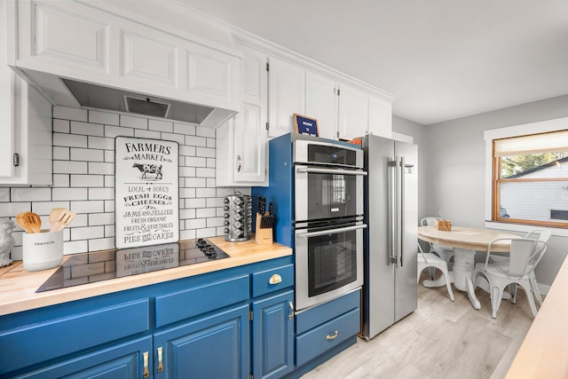 kitchen featuring decorative backsplash, stainless steel appliances, light wood-type flooring, blue cabinetry, and white cabinets