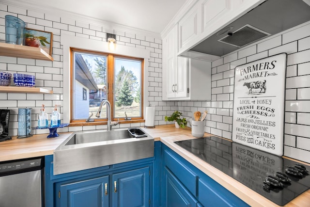 kitchen with butcher block counters, blue cabinetry, stainless steel dishwasher, and a sink