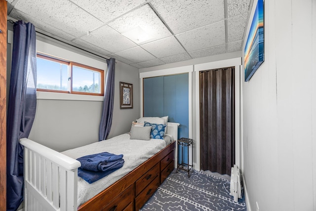 bedroom with a drop ceiling and a baseboard radiator