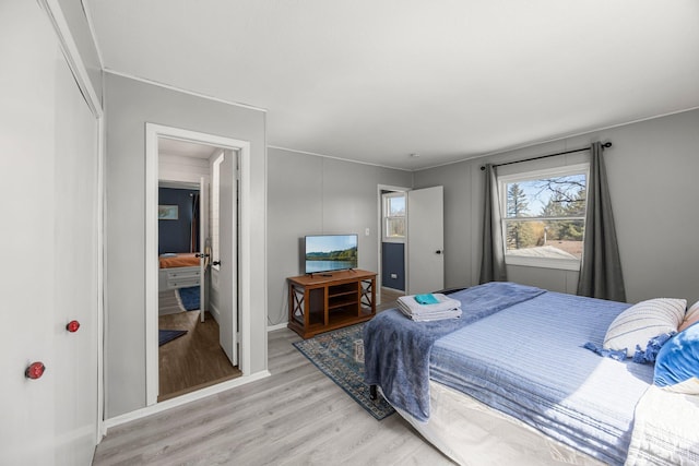 bedroom with light wood-type flooring and baseboards