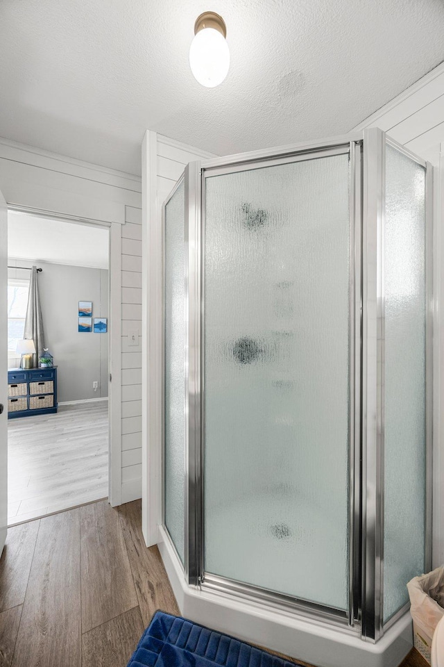 bathroom with a stall shower and wood finished floors