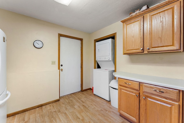 1786 English St, Maplewood, MN 55109 - laundry room with estacked washer and dryer, light wood finished floors, and baseboards