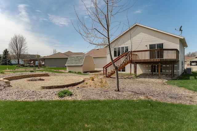 506 6th Pl NE, Byron, MN 55920 - rear view of property featuring stairs, a wooden deck, cooling unit, a lawn, and an outdoor structure