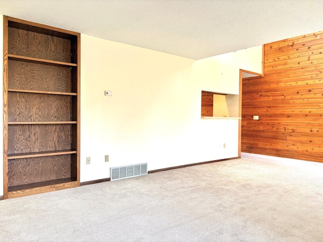 1826 Coolidge Ct, Northfield, MN 55057 - carpeted spare room with wooden walls, baseboards, a textured ceiling, and visible vents