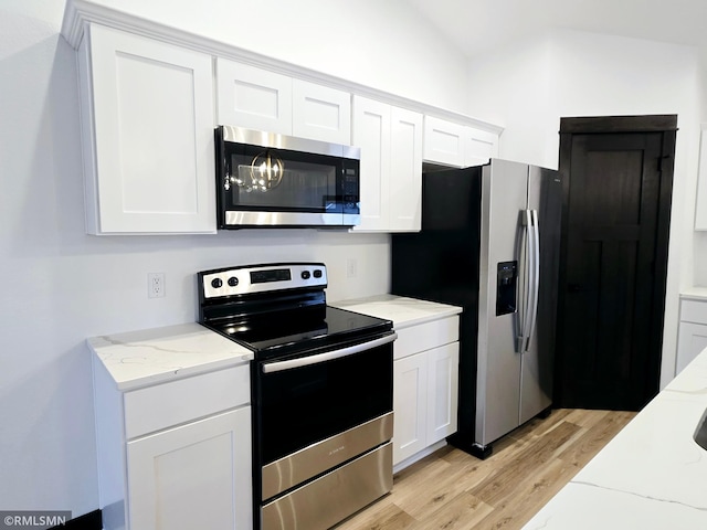 kitchen with light wood-style flooring, white cabinetry, light stone countertops, and stainless steel appliances
