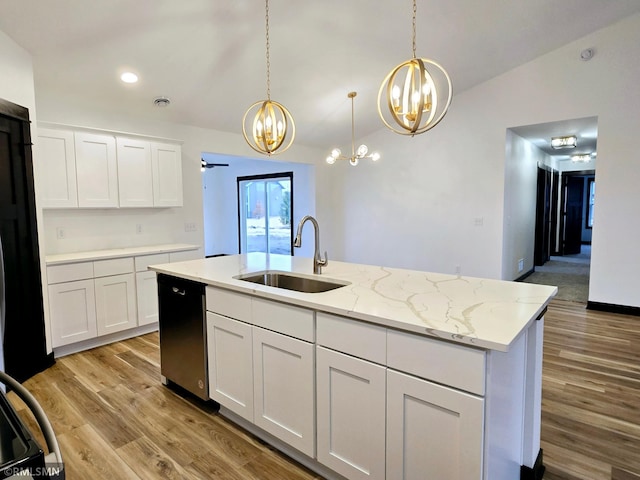 kitchen with stainless steel dishwasher, a sink, a chandelier, lofted ceiling, and white cabinetry