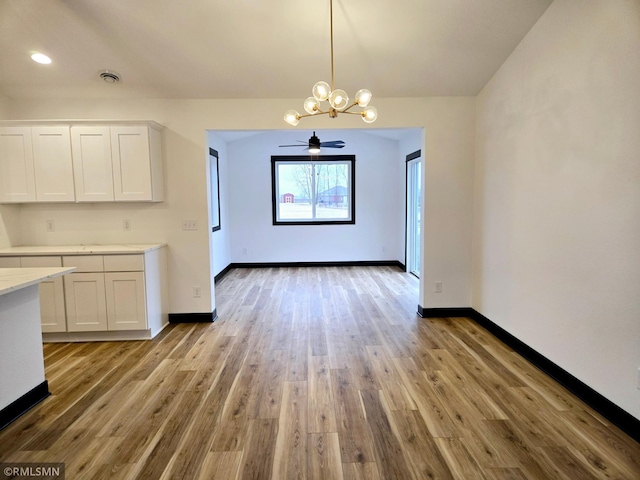 unfurnished dining area with visible vents, baseboards, and wood finished floors